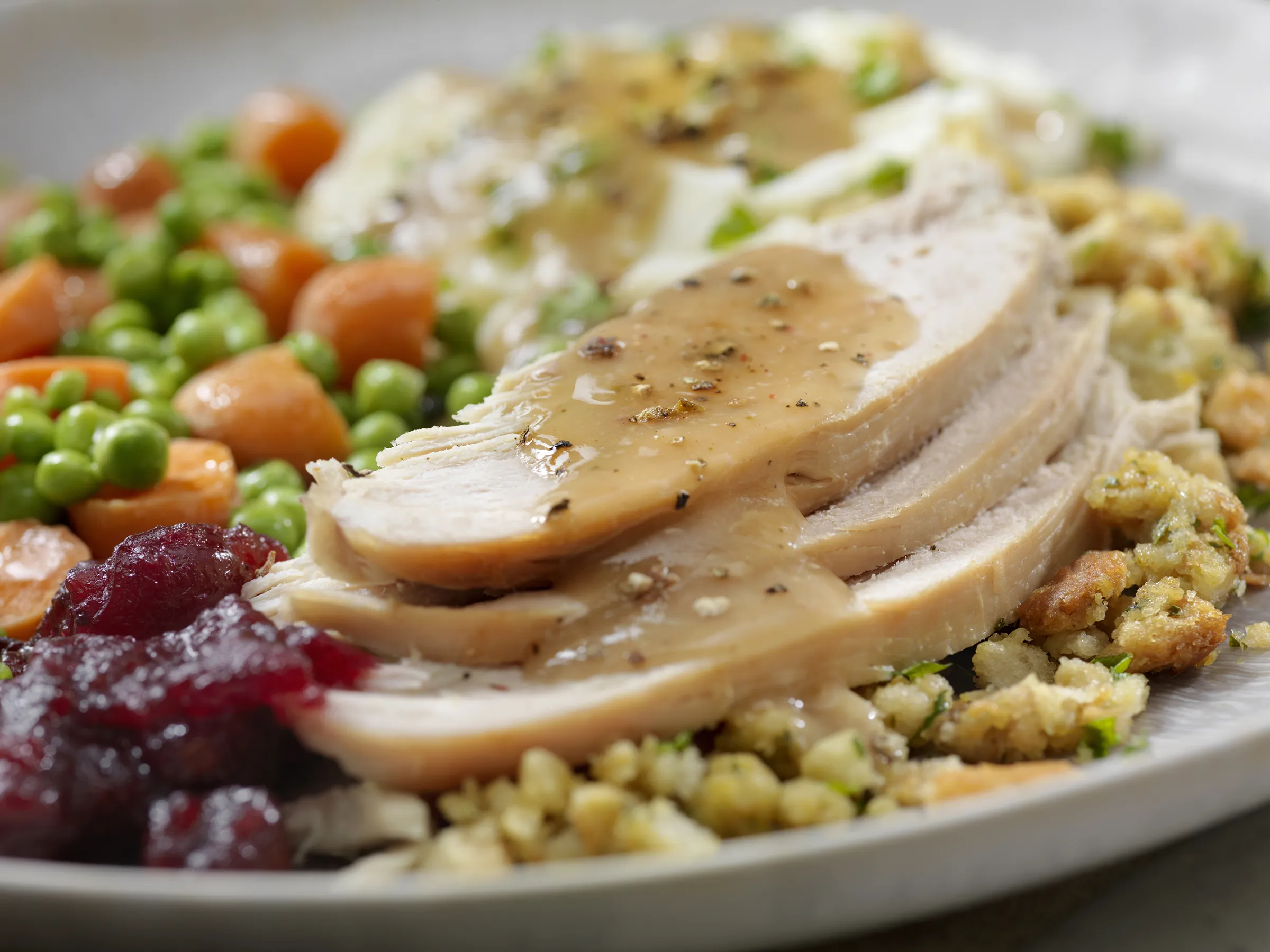 Sliced turkey with gravy and holiday side dishes
